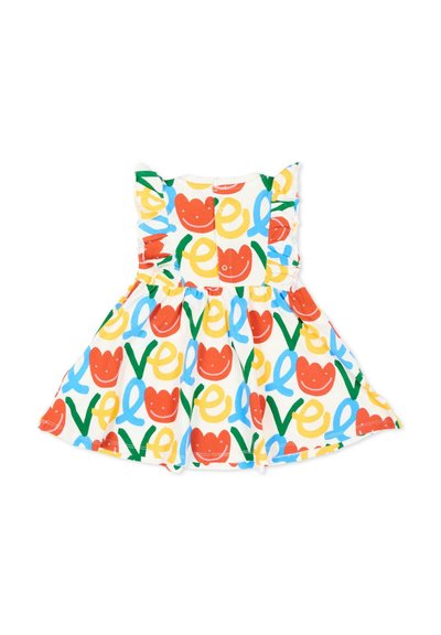 Vestido blanco sin mangas para niña pequeña con hombros fruncidos, con un patrón colorido de caras sonrientes rojas y lazos abstractos en amarillo, verde y azul.