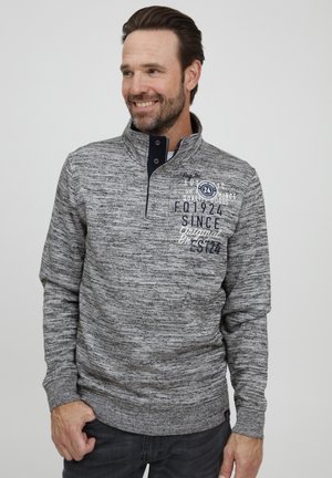 Gray knit pullover featuring a stand-up collar, textured fabric, and navy accents. Displays printed text and logo details on the front.