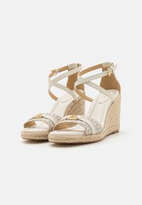 Wedge sandals with light beige leather and patterned fabric straps, featuring gold hardware and a braided jute sole.