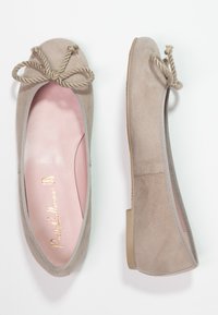 Beige ruskind ballet flade med rund tå, pyntet med grå kant, prydet med en dekorativ knyttet rebdetalje foran og en lyserød indersål.