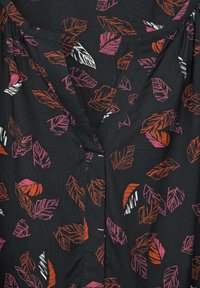 Svart blus i tyg med ett bladmönster i rosa, vitt och orange. V-ringad design med rynkdetaljer vid axlarna.