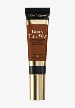 Too Faced Born This Way Soft Matte oliecontrole foundationtube in medium-diepe tint met goudkleurige en zwarte dop en tekst over 24 uur langdurig dragen.