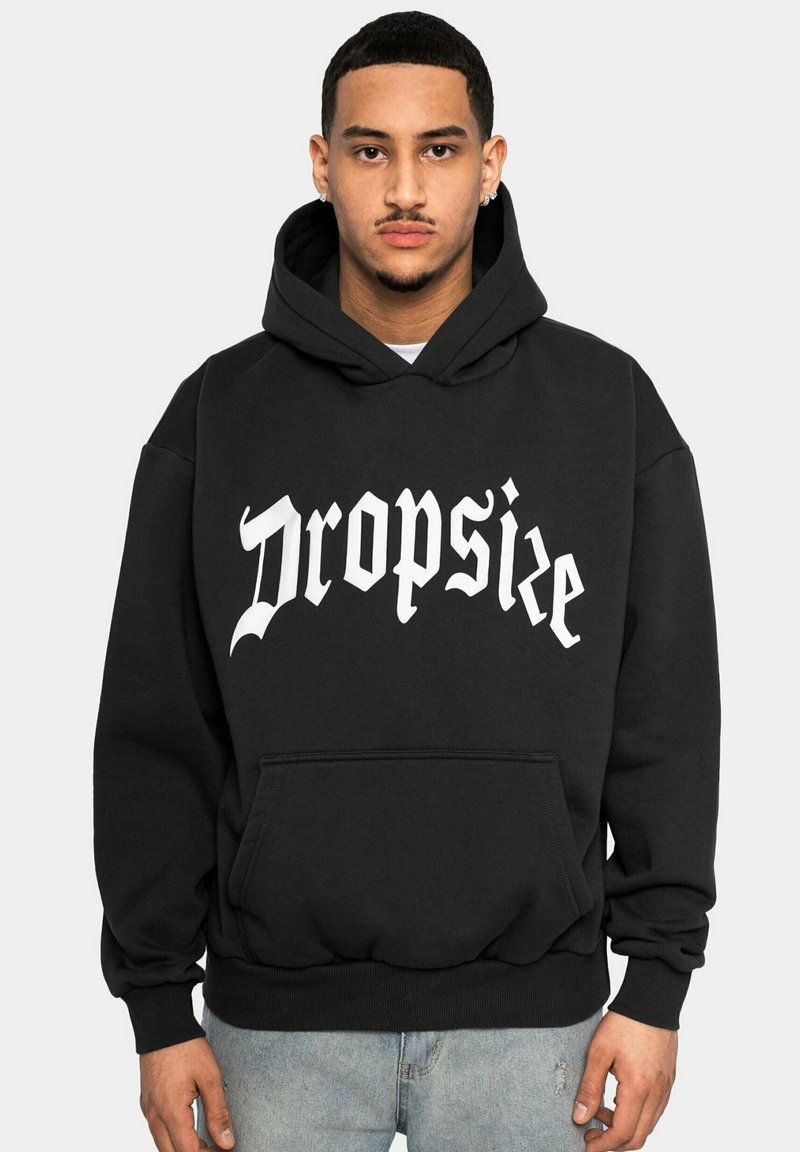 Svart hettegenser med frontlomme, med "Dropsize" i store hvite bokstaver. Laget av myk stoff med ribbede mansjetter og nedkant.