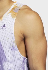 Canotta atletica senza maniche in tessuto a rete traspirante di colore bianco con motivi astratti in viola e arancione. Design resistente e leggero.