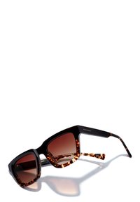 Ochelari de soare pătrați cu un cadru negru și accente de țestoasă. Lentile brown cu gradient. Numele brandului gravat pe braț. Textură netedă.