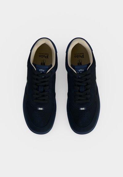 Ζευγάρι σκούρα μπλε αθλητικά παπούτσια Polo Ralph Lauren με μαύρα κορδόνια και μπεζ εσωτερική επένδυση, από πάνω σε λευκό φόντο.