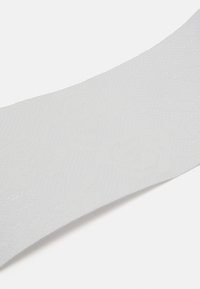 Balts teksturēts audums ar smalku rakstu; tam ir gluda virsma un viegla spīduma efekts. Redzama izliekta mala, uzsverot tās elastīgo dizainu.