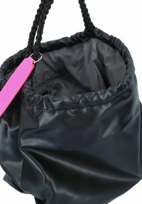 Sac seau en cuir noir avec une finition texturée, doté d'un haut froncé, d'une anse tressée noire et d'un accent d'étiquette rose vif.