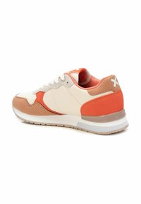 Zapatillas retro con una parte superior de malla color crema, acentos de ante marrón claro y una etiqueta en el talón de color naranja vibrante. Suela de goma con relieve para una mejor tracción.