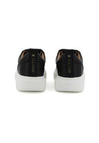 Sneaker in pelle nera con suola in gomma bianca, dotate di un logo dorato sul retro e una texture liscia. Design minimalista.