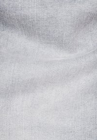 Világosszürke farmeranyag, látható átlós szövésű textúrával és finom ráncokkal.