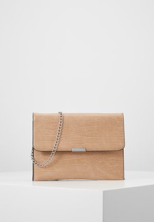 Beigen värinen tekonahkainen krokotiilikuosinen clutch-laukku, jossa hopeinen ketjuhihna ja suorakaiteen muotoinen metallinen koriste edessä, esillä valkoisella jalustalla.
