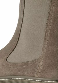 Botte chelsea taupe en daim avec des côtés en tissu extensible beige, des coutures détaillées et une semelle en caoutchouc texturée. Surface lisse et silhouette courbée.