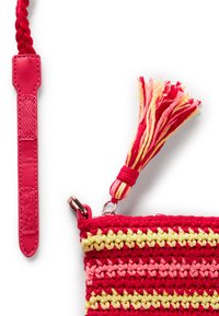 Borsa all'uncinetto rossa e gialla caratterizzata da una superficie testurizzata, una tracolla intrecciata e rimovibile, e un accento di nappina colorata.