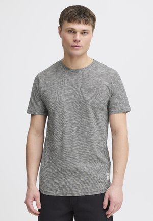 Tricou gri cu mânecă scurtă, cu o croială lejeră, având un model subtil în dungi și un guler rotund. Etichetă pe lateral la tiv.
