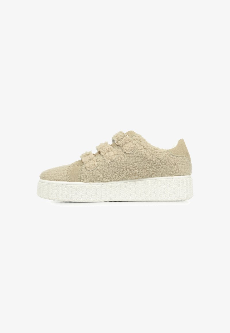 Sneakers en fausse fourrure beige avec semelle plate-forme, dotées de trois bandes décoratives et d'une semelle en caoutchouc blanc texturé. Vue de côté sur fond blanc.