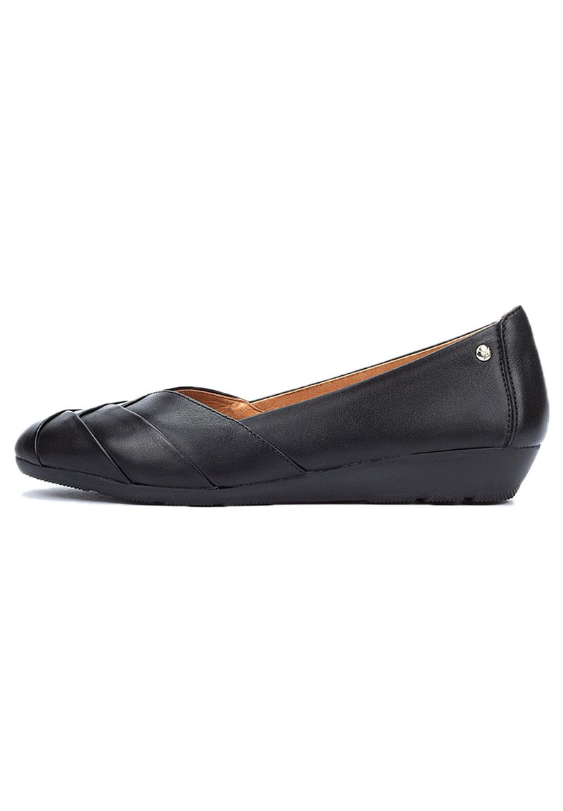 Chaussures ballerines noires en cuir avec une surface légèrement texturée, présentant un design de bride croisée et une semelle compensée basse pour le soutien.
