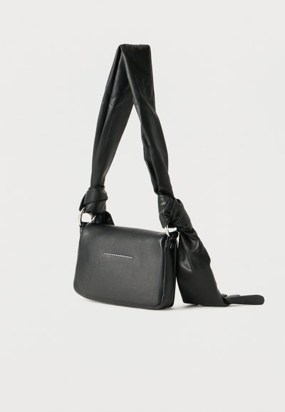 Μαύρη ορθογώνια τσάντα ώμου με δεμένο στριφτό λουράκι και διακριτικές οριζόντιες ραφές στην εμπρόσθια πτύχωση.