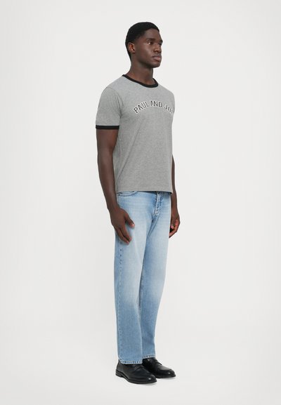 Gray short-sleeve t-shirt with black ribbed neckline, featuring "PAUL AND JOE" in contrasting text. Paired with light blue straight-leg jeans.
