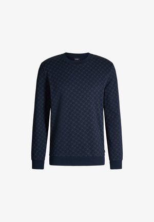 Granatowy sweter z teksturowanym wzorem heksagonów, z prążkowanymi mankietami i dołem oraz okrągłym dekoltem. Materiał wydaje się być miękki.