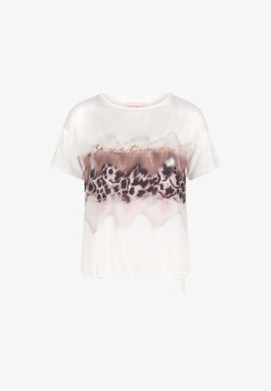 Blouse blanche à manches courtes avec bande à imprimé léopard abstrait marron et texte métallique indiquant "Parfois, moins c'est plus" sur la poitrine.