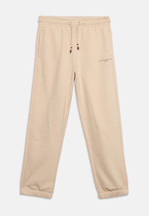 Beżowe spodnie dresowe z elastycznym pasem i mankietami, sznurkiem ze wskazówkami w kolorach czerwonym, białym i niebieskim oraz małym logo Tommy Hilfiger na lewej uda.