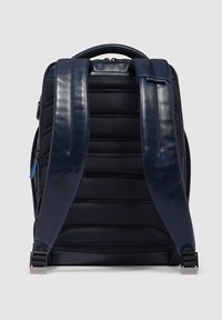 Marine rugzak met een gewatteerde textuur, leren banden en blauwe accentritsen. Inclusief een handvat bovenop en een versterkte basis voor duurzaamheid.