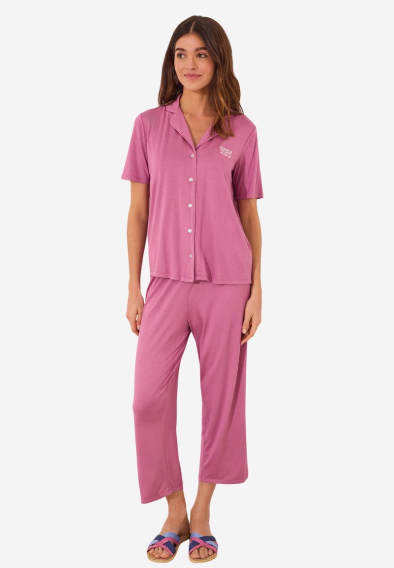 Roze short-sleeve pyjama set met knoopsluiting, relaxte broek en een subtiele logodetail op het shirt. Zacht, lichtgewicht materiaal.