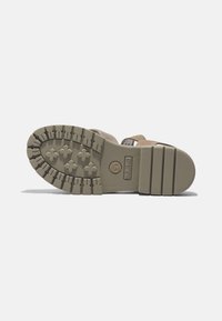 Beige sandaler med en texturerad gummisula som har framträdande lugs, en logotyp och justerbara remmar för en säker passform.