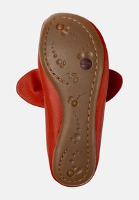 Zapato de cuero rojo con suela de goma marrón flexible, que presenta costuras decorativas y patrones similares a burbujas en la parte inferior.