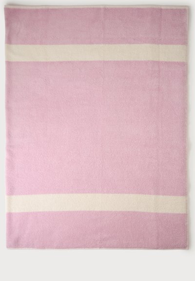 Serviette rose douce avec deux bandes blanches horizontales, une près du bord supérieur et une près du bord inférieur, étendue à plat sur une surface blanche.