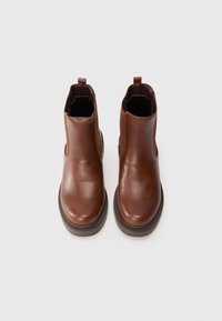 Botas de tobillo de cuero marrón con un acabado suave, paneles laterales elásticos y puntera redonda. Presenta una suela marrón resistente para agarre y durabilidad.