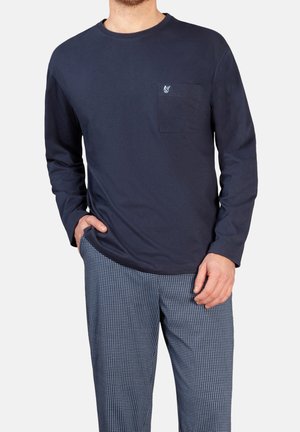 Marineblaues langärmeliges Baumwoll-T-Shirt mit einer Brusttasche und kleinem Logo. Ergänzt durch gemusterte, locker geschnittene Hosen in hellblauen Tönen.