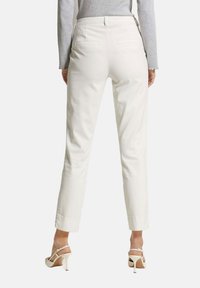 Witte op maat gemaakte broek met een rechte pijp, met twee achterzakken en een gladde textuur. Draag het met lichtgekleurde hoge hakken.