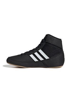 Chaussure de sport noire avec des rayures blanches, présentant un design montants et des panneaux en mesh pour la respirabilité. Semelle en caoutchouc texturée pour l'adhérence.