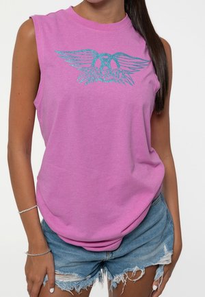 Pink sleeveless t-shirt with a glittery blue winged graphic design. Material is soft; cut is relaxed. Worn with distressed denim shorts.