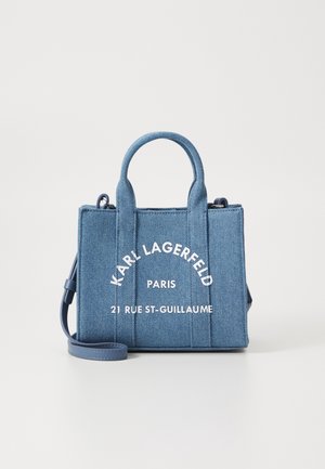Kleine blauwe denim handtas met bovenhandvatten, afneembare schouderriem en witte tekst "Karl Lagerfeld Paris 21 Rue St-Guillaume" aan de voorkant.
