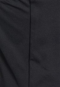 Tecido preto com uma superfície texturada e estriada, apresentando um caimento suave, seções dobradas e um brilho subtil. Adequado para várias vestimentas.