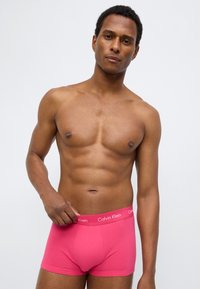 Boxer acolchados rosas con el logo de Calvin Klein en la cintura. Material de algodón suave, diseño ajustado con bolsa anatómica.