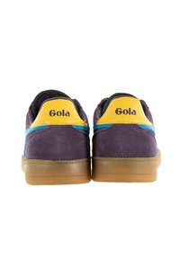 Purple suede sneakers with a yellow and blue accent on the heel, featuring a rubber sole and the "Gola" logo in black on the back.