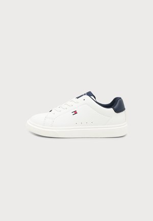 Λευκό sneaker χαμηλού κοψίματος με ναυτικό μπλε φτέρνα και γλώσσα, λευκά κορδόνια και μικρό κόκκινο, λευκό και μπλε λογότυπο σημαίας στο πλάι.