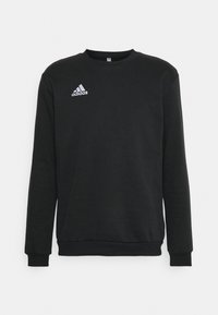 Felpa nera realizzata in tessuto morbido, con collo rotondo, maniche lunghe, polsini a coste e logo adidas ricamato in bianco.