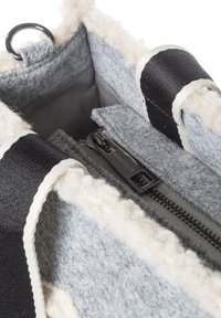 Grijze vilten tas met zwarte accenten en een zachte crèmekleurige voering. Voorzien van een ritssluiting en een metalen ring. Binnenkant gevoerd met grijs materiaal.