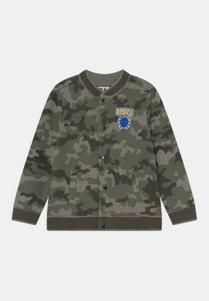 Chaqueta con patrón de camuflaje en tonos verdes, presenta un cuello redondo, botones a presión y un logo bordado de "SPIDEY" en azul y amarillo.