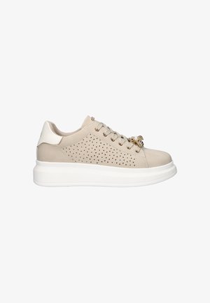 Zapatilla beige de corte bajo con suela blanca, perforaciones triangulares en el lateral, cordones delanteros y detalle decorativo de oro y perlas en los cordones.