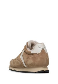Suede sneaker in light brown with a white accent. Features a cushioned interior and a textured outsole for grip. Rounded toe design.