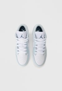 Białe i jasnoniebieskie sneakersy mają górną część wykonaną z gładkiej skóry, siateczkowy język, perforowany czubek oraz niebieskie logo Jumpman na języku.