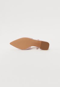 Escarpin rose à bout pointu, avec un dessus lisse, une bride de cheville et une semelle en caoutchouc marron texturée.
