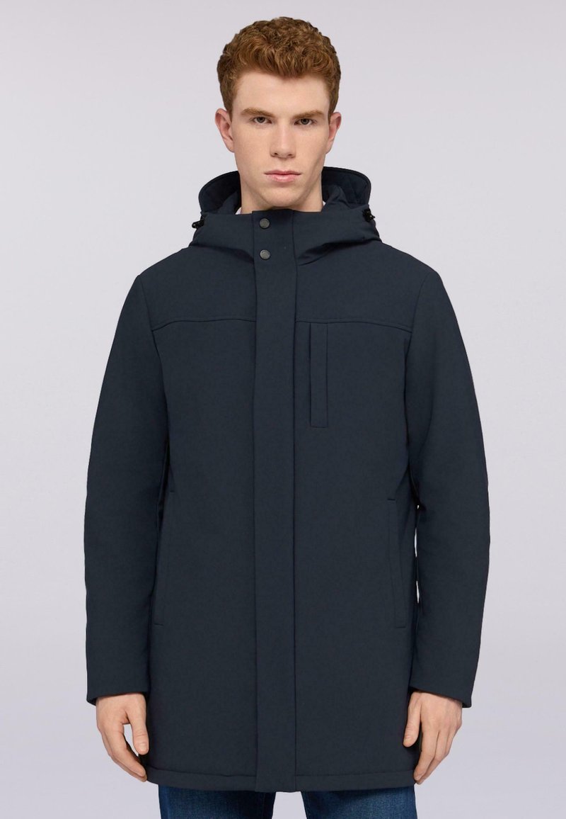 Chaqueta con capucha en azul marino, con cierre frontal de cremallera y broche a presión, que presenta un hardware discreto, bolsillos laterales y un diseño minimalista.