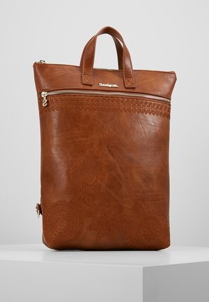 Brun læder tote taske med præget blomster mønster, top lynlåslomme, to håndtag og metal Desigual logo på ensfarvet baggrund.